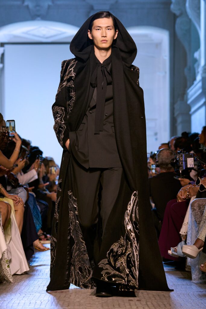 A relaxed black silk coat with a hood and long sleeves, paired with matching pants featuring embroidered details.