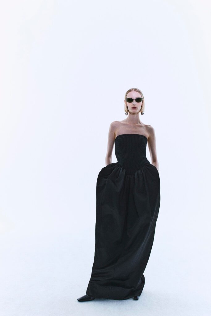 A fitted black cotton strapless maxi dress with a sleek silhouette.