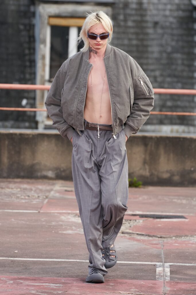 A relaxed gray jacket with long sleeves paired with pleated wide-leg pants.