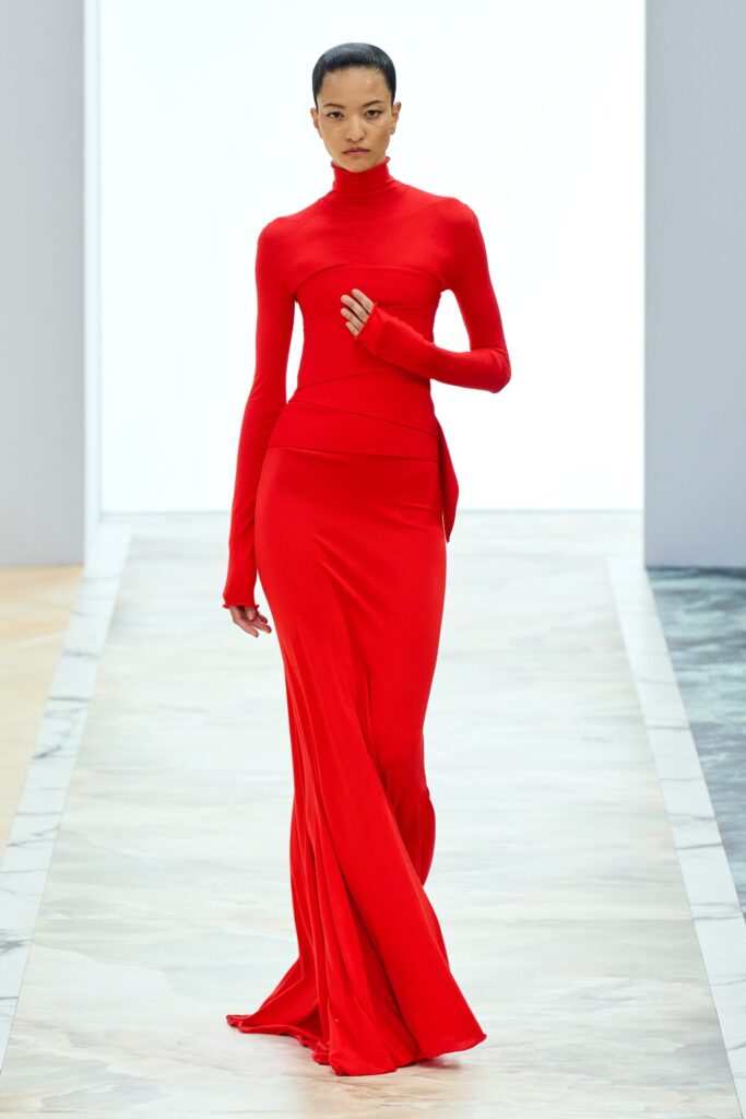 A fitted red long-sleeve dress with a high neckline and straight-leg silhouette.