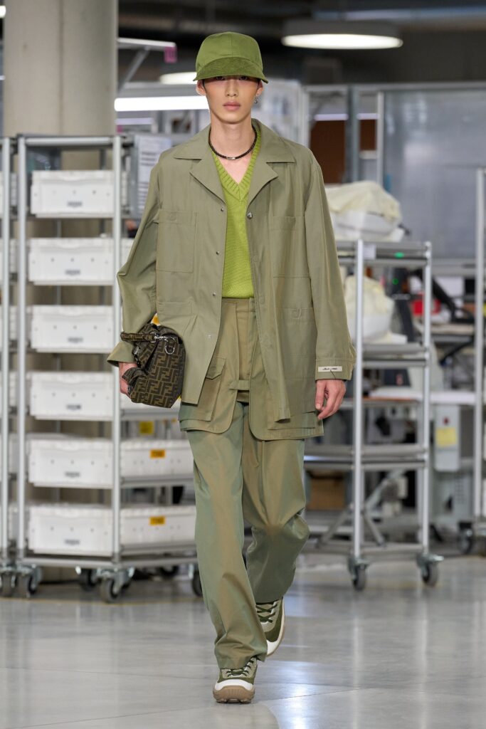 A relaxed green cotton jacket with long sleeves and collared design paired with straight-leg pants.