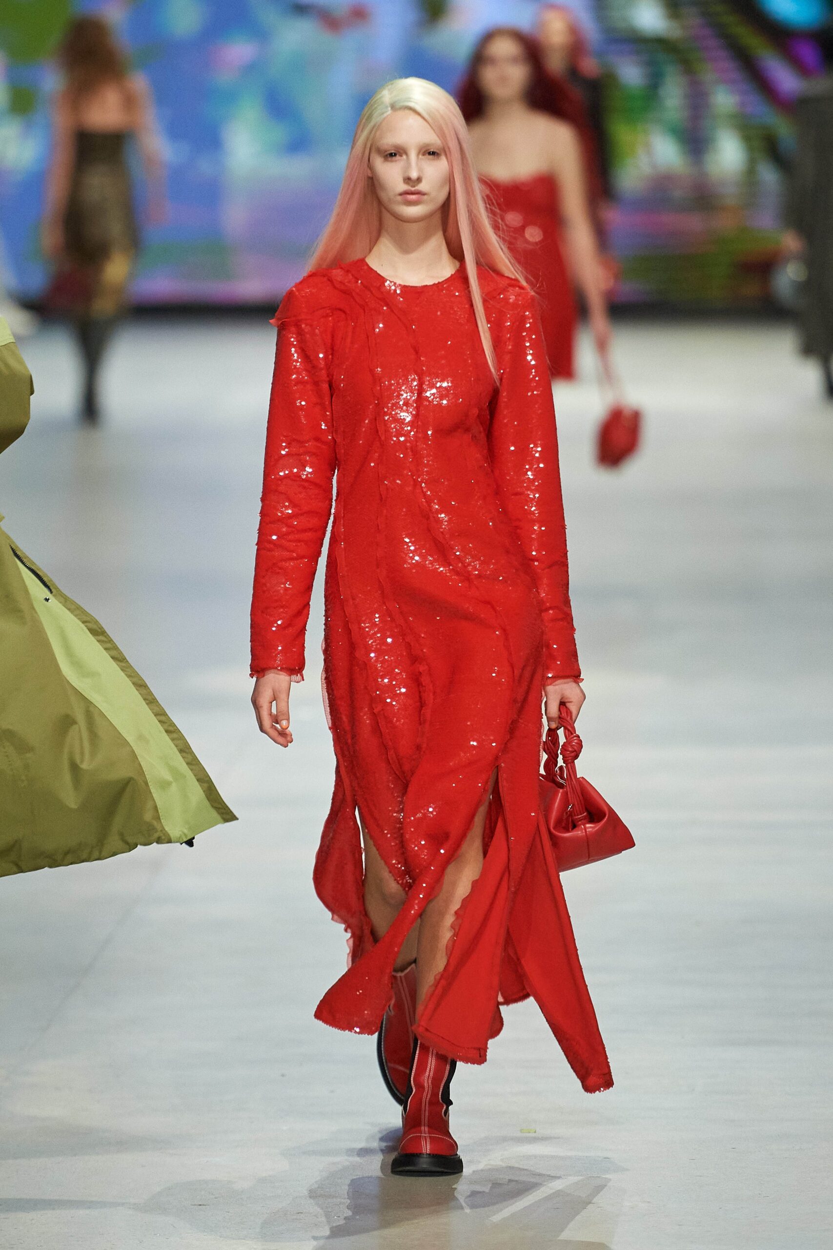 A fitted red sequin dress with long sleeves and a V-neckline featuring a slit.