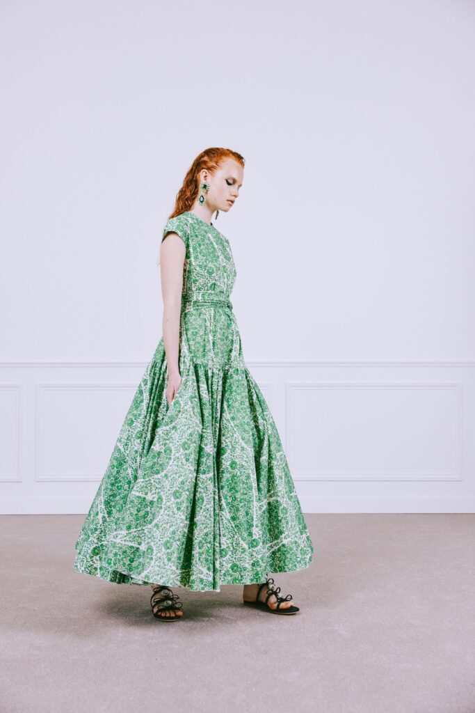 A relaxed green cotton short-sleeve dress with a high neckline and tiered design.