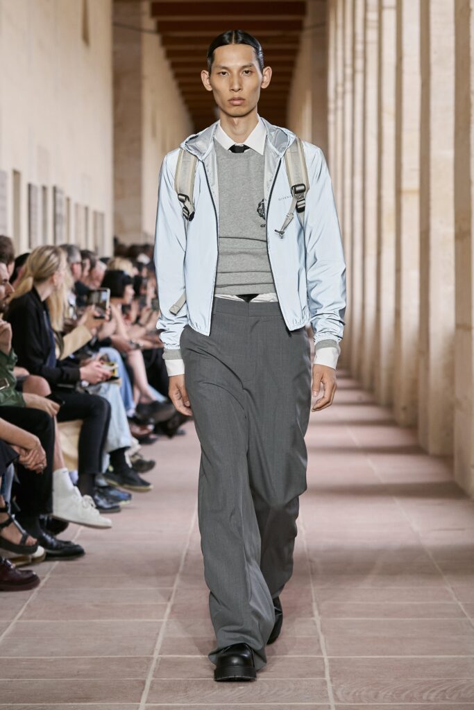 A relaxed blue cotton jacket with a collared neckline paired with gray straight-leg pants.