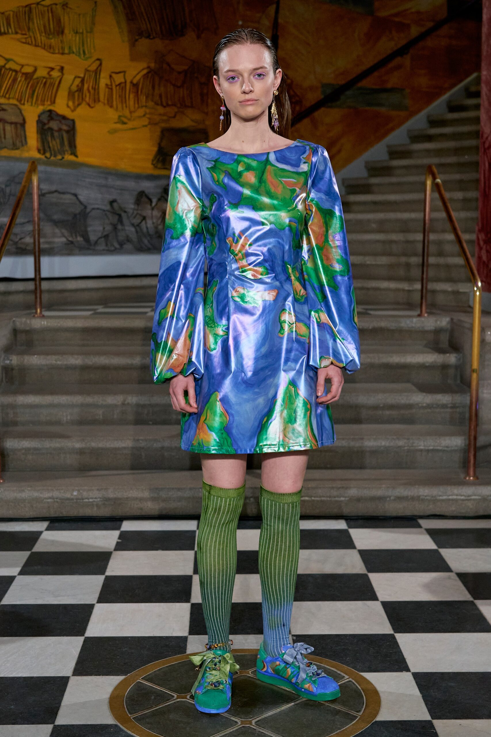 A fitted blue silk dress with long sleeves and a printed design.