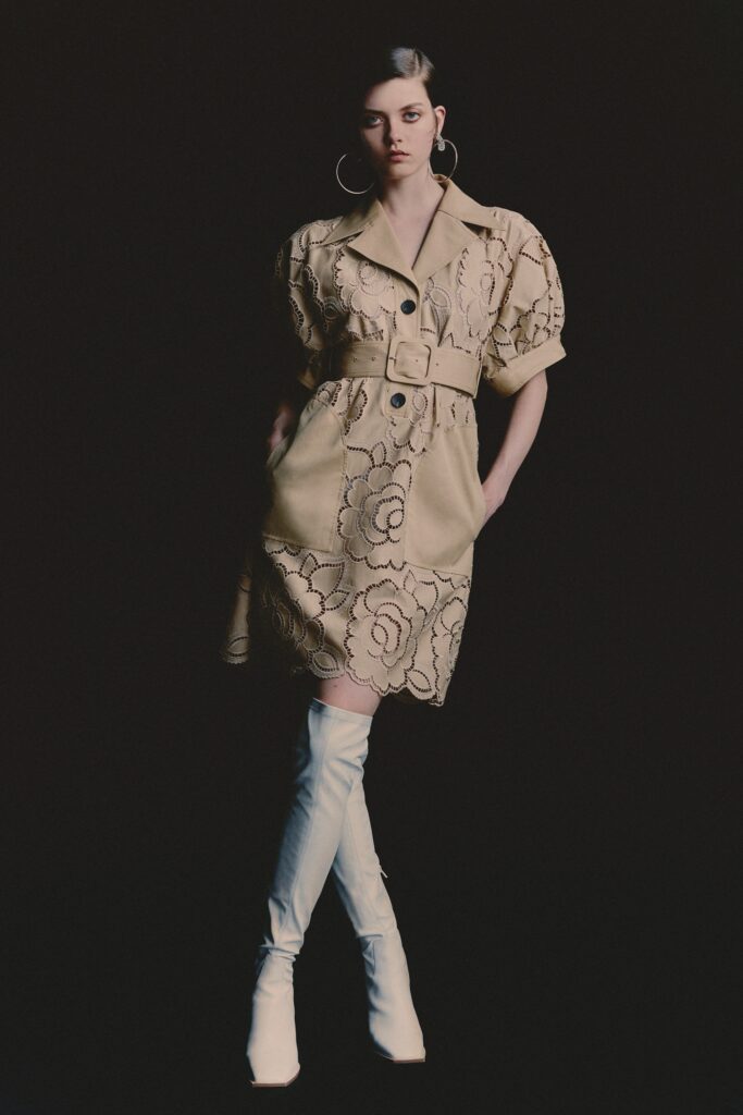 A fitted beige dress with short sleeves, a collar, and embroidered floral details.