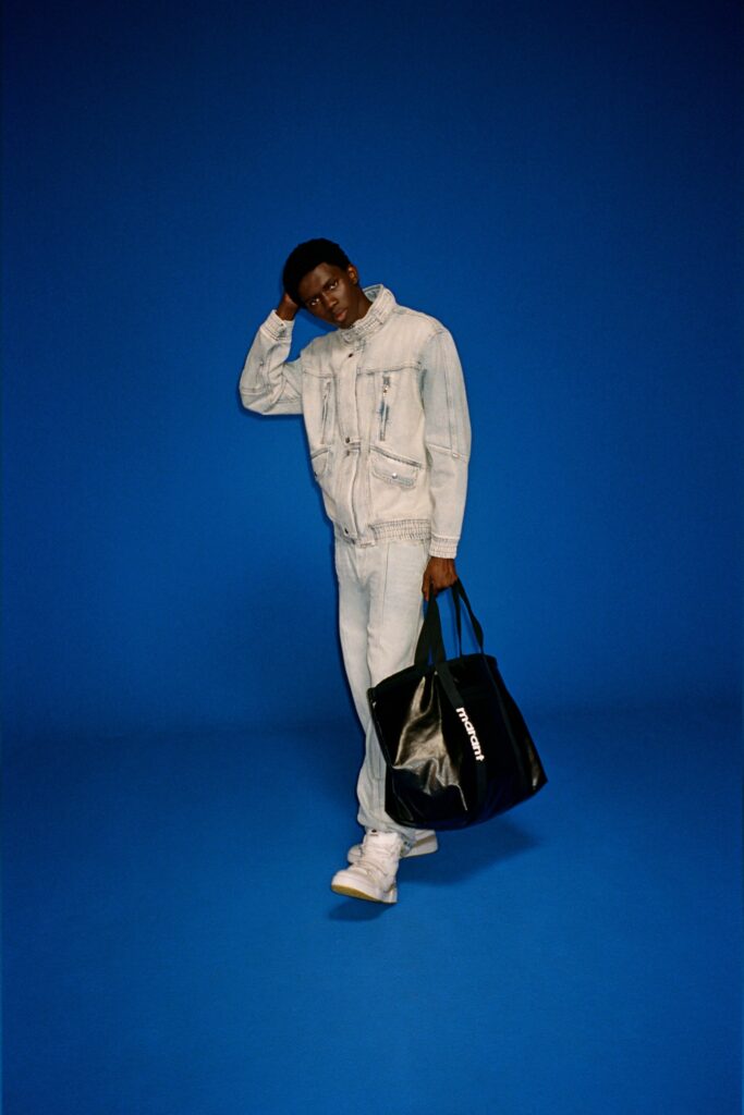 A fitted blue denim jacket with long sleeves and a collared neckline paired with matching pants.