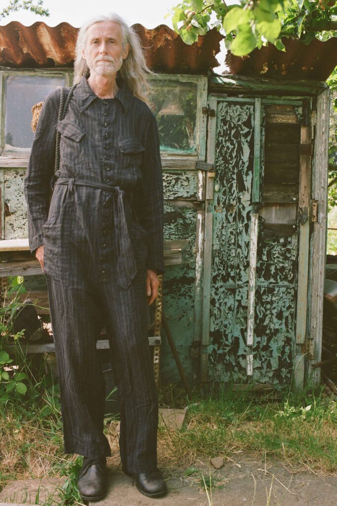 A relaxed black cotton jumpsuit with long sleeves and a collared neckline, featuring button details.