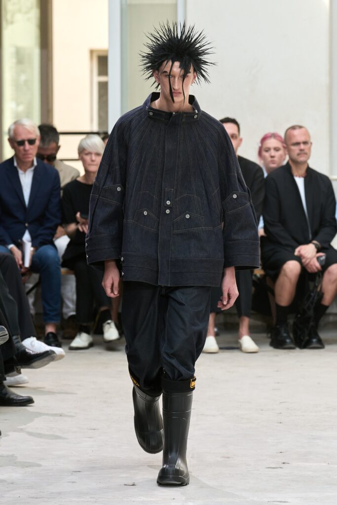 A relaxed black denim jacket with long sleeves paired with matching pants.