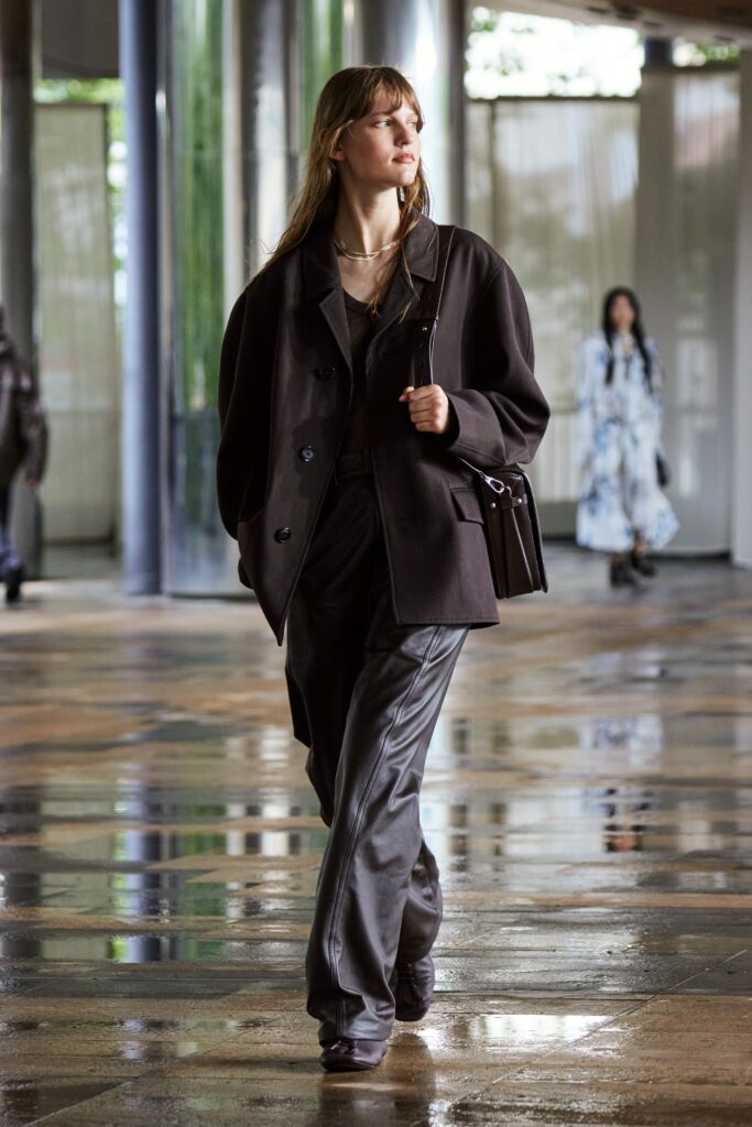A relaxed black leather jacket paired with straight-leg pants, creating a chic ensemble.