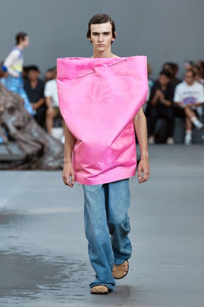 An oversized pink printed top paired with blue jeans for a bold runway look.