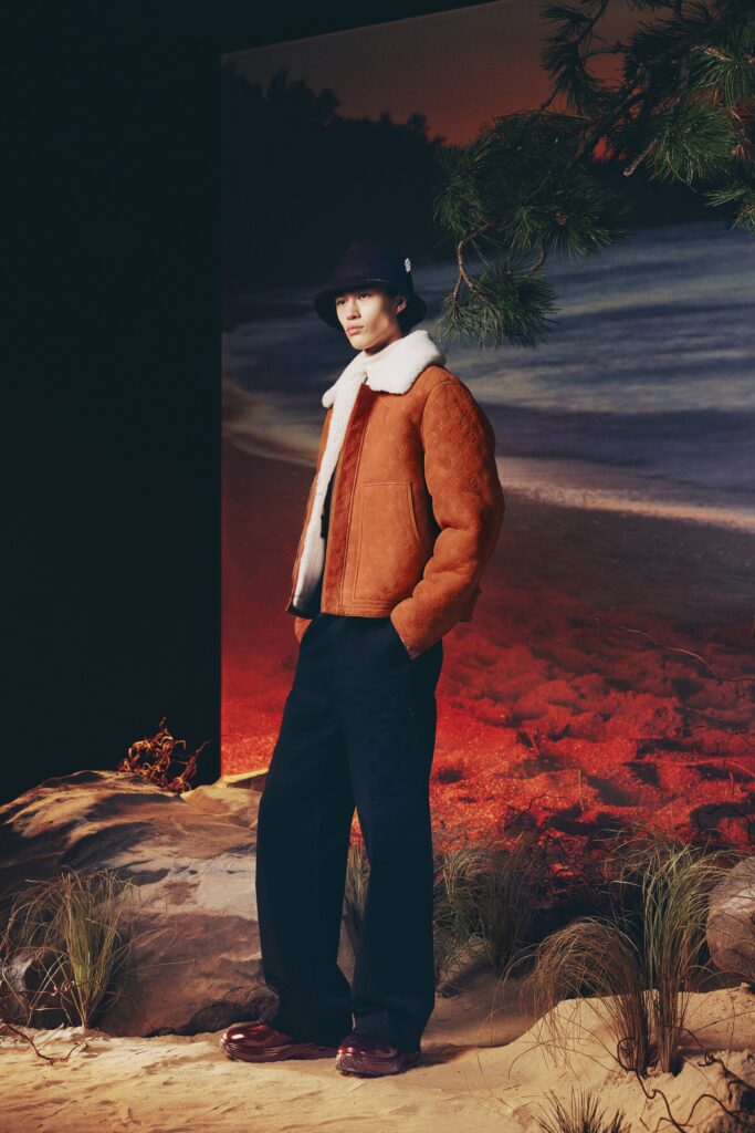 A relaxed brown leather jacket with a collared neckline paired with wide-leg black pants.