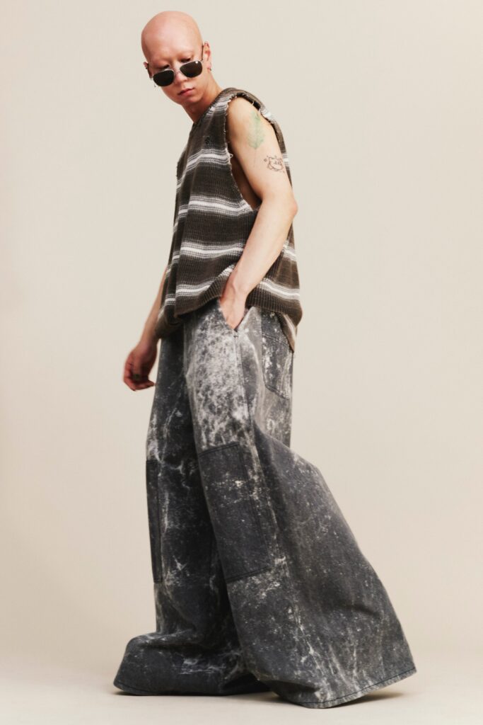 A relaxed gray and brown striped sleeveless top paired with high-waisted wide-leg pants.