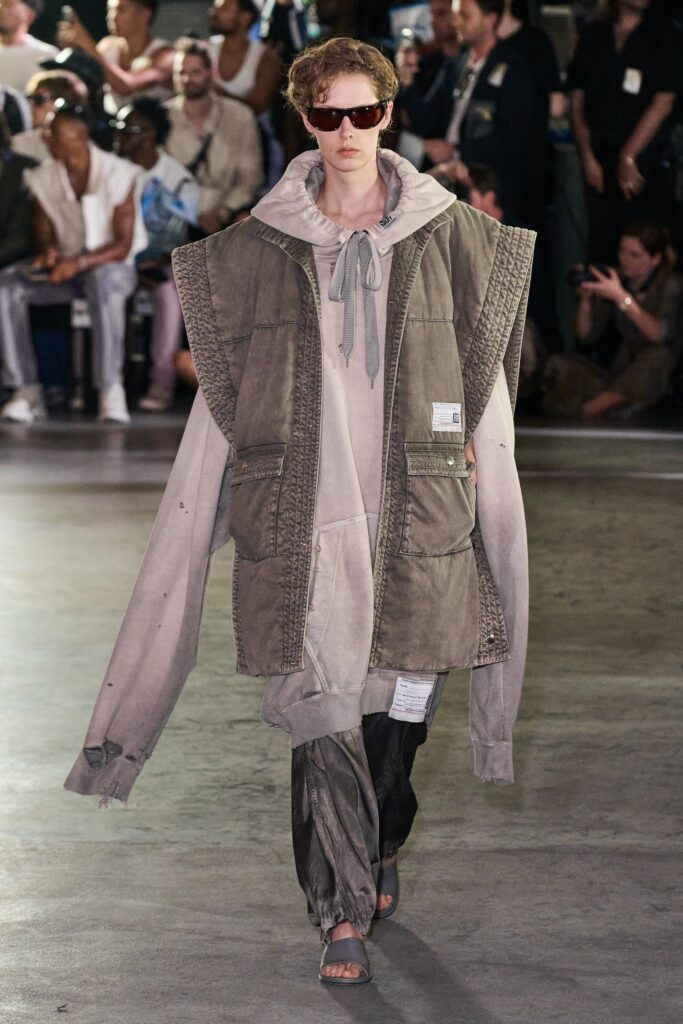 An oversized gray cotton jacket with a hood and layered design, paired with matching pants.