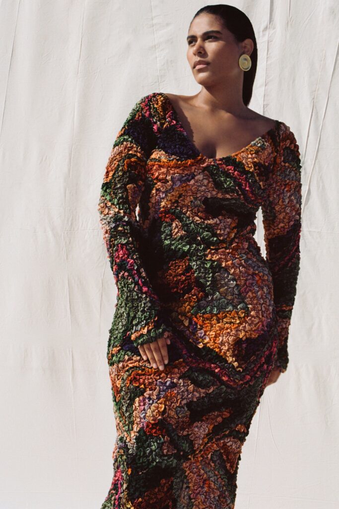 A fitted multicolor long-sleeve dress with a V-neckline and flared silhouette.