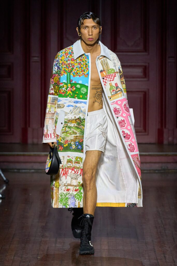 A relaxed white coat with long sleeves, a collared neckline, and colorful printed designs.