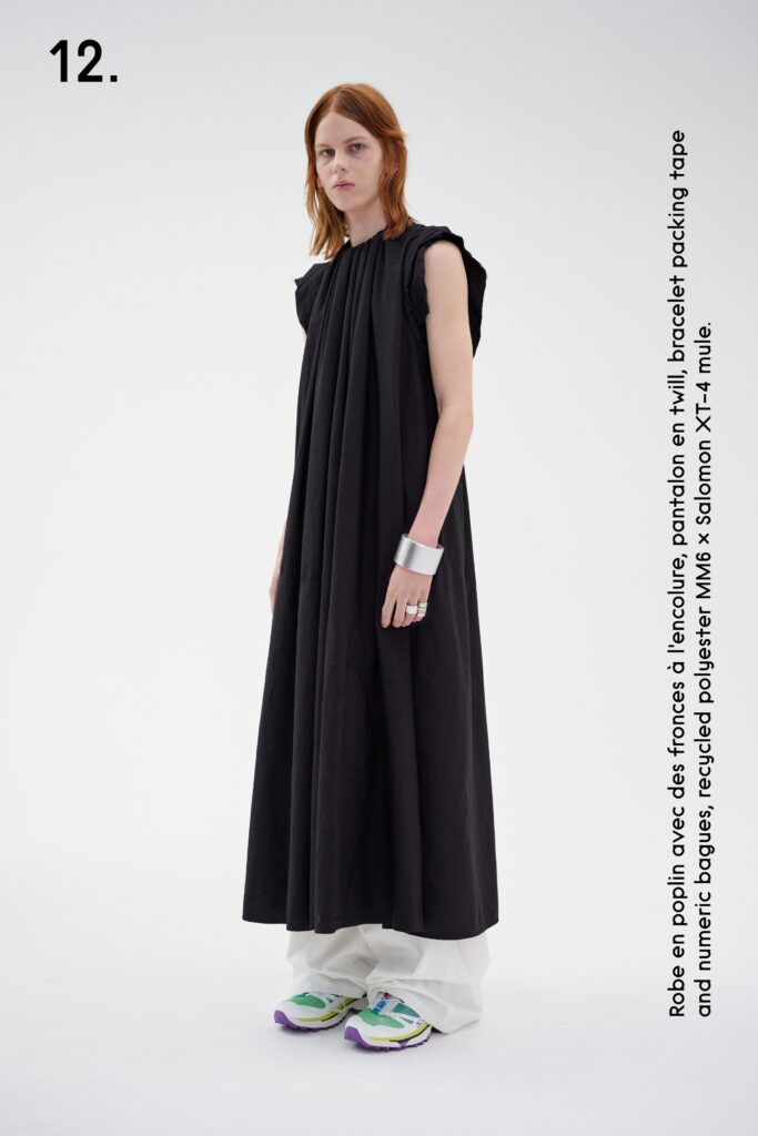 A relaxed black sleeveless dress with a high neckline and pleated design.