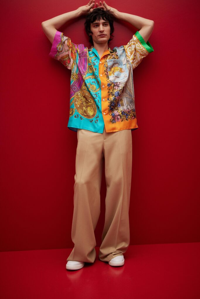 This shirt features a vibrant mix of colors and intricate prints, creating a striking visual impact. Paired with relaxed-fit pants, the ensemble balances boldness with comfort, allowing for effortless movement and a contemporary silhouette.