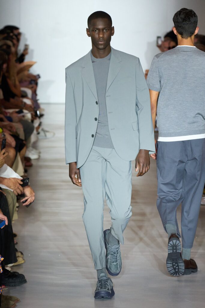 A tailored gray suit with a collared long-sleeve shirt and buttoned details.