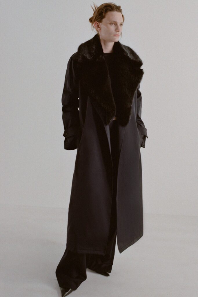 A relaxed black leather coat with a collared design and asymmetric silhouette.