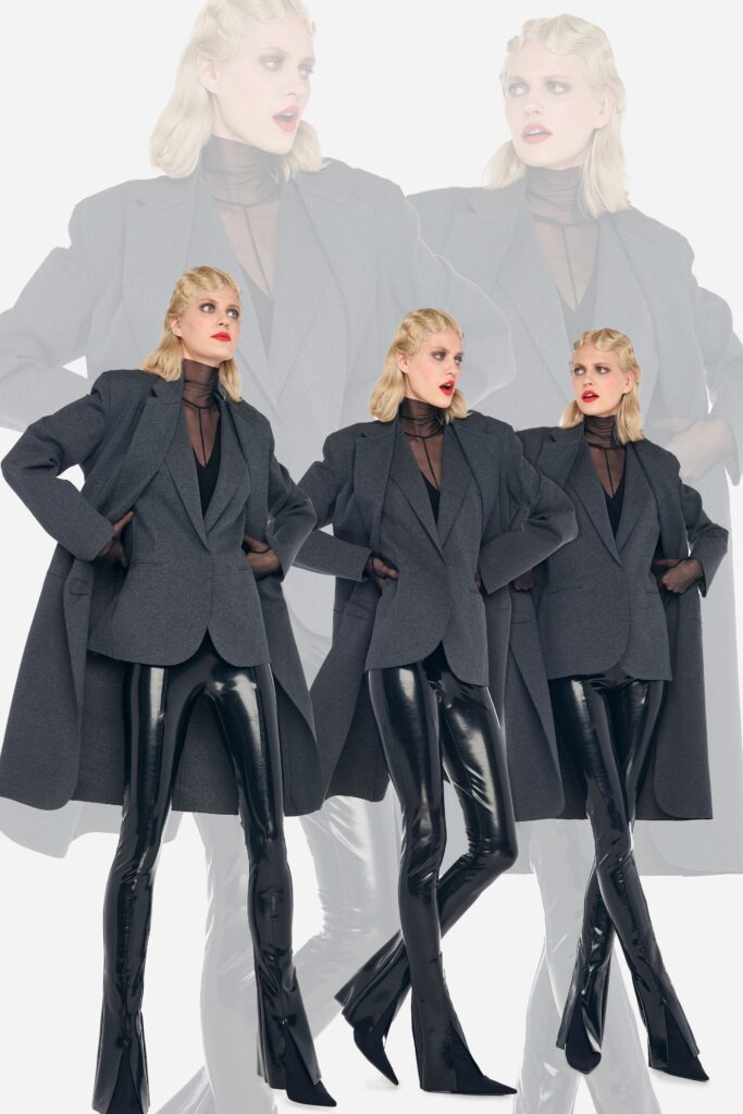 A fitted gray coat with a structured design paired with sleek black leather pants.