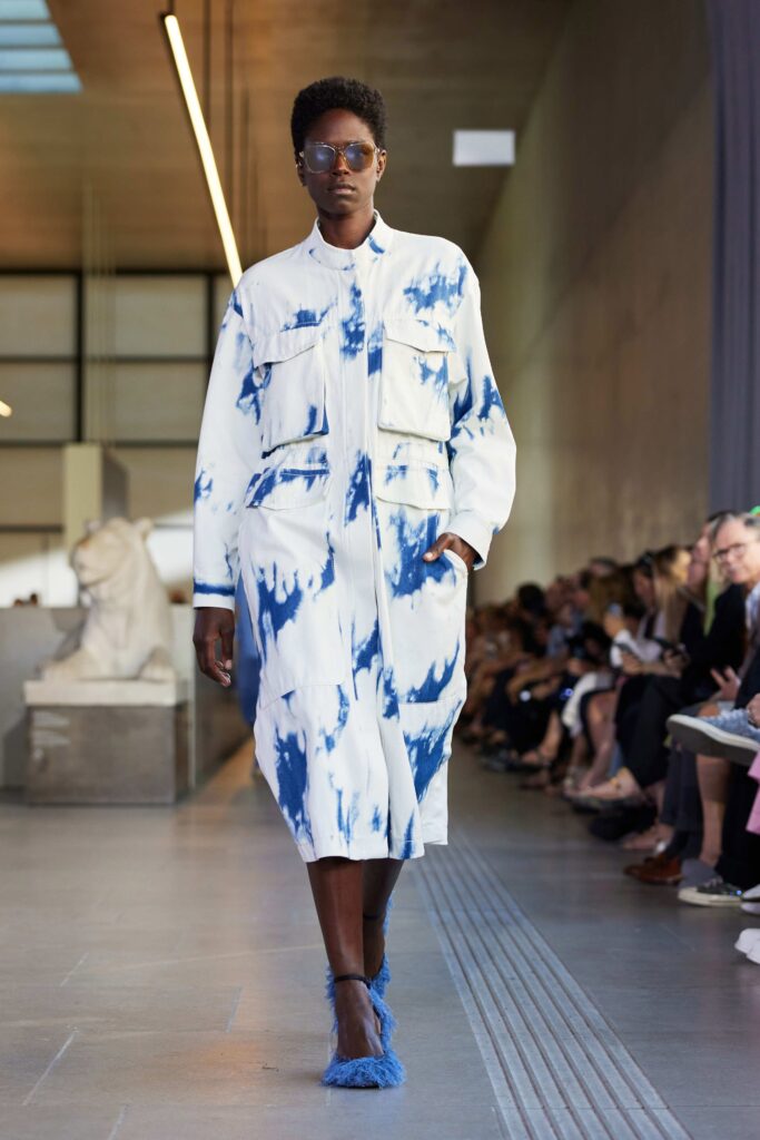 An oversized white dress with blue tie-dye patterns and buttoned front details.