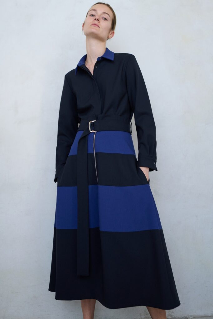 A relaxed navy blue striped dress with long sleeves and a belted waist.