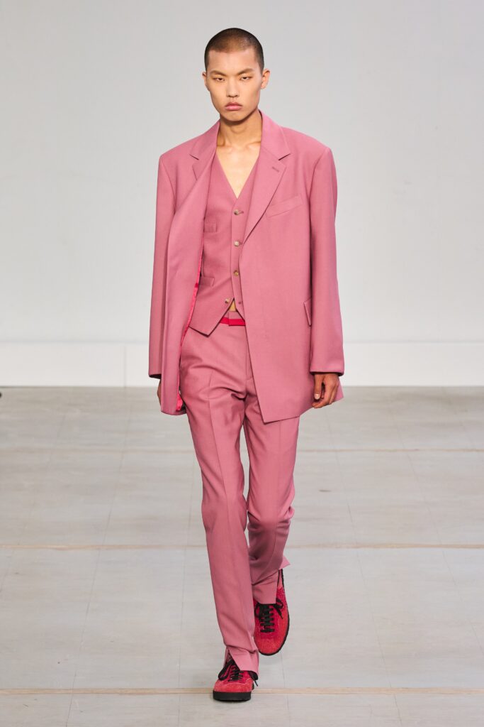 A tailored pink suit with long sleeves and buttoned details, perfect for a stylish look.
