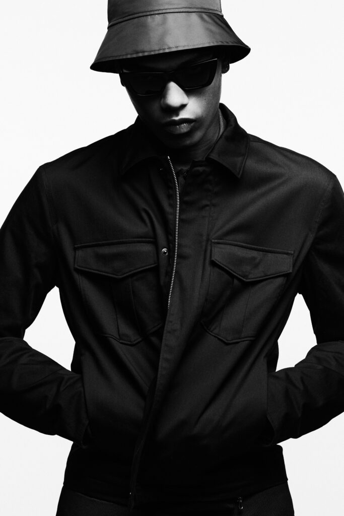 A fitted black cotton jacket with long sleeves and a zippered front.
