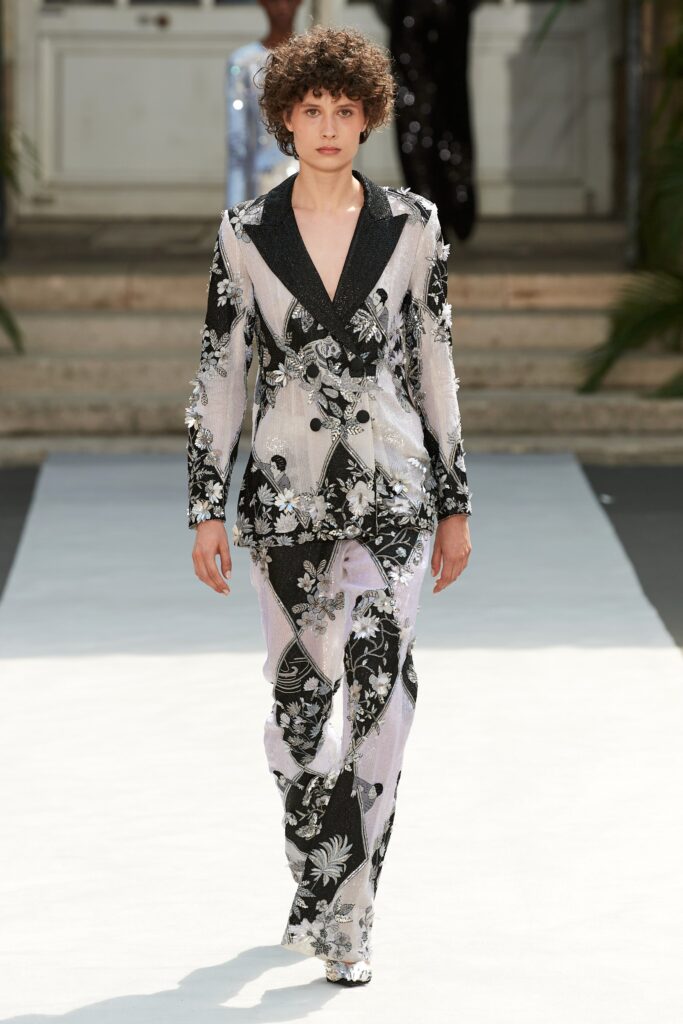 A tailored suit featuring a black and white floral print with long sleeves and a collared design.