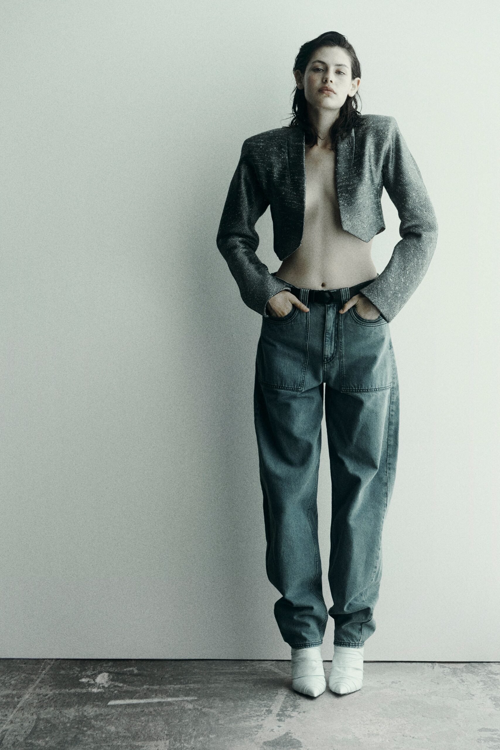 A relaxed gray long-sleeve jacket paired with wide-leg blue denim pants.