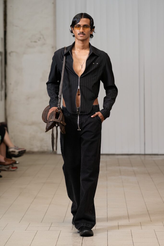 A fitted black long-sleeve shirt paired with black pants, creating a sleek silhouette.