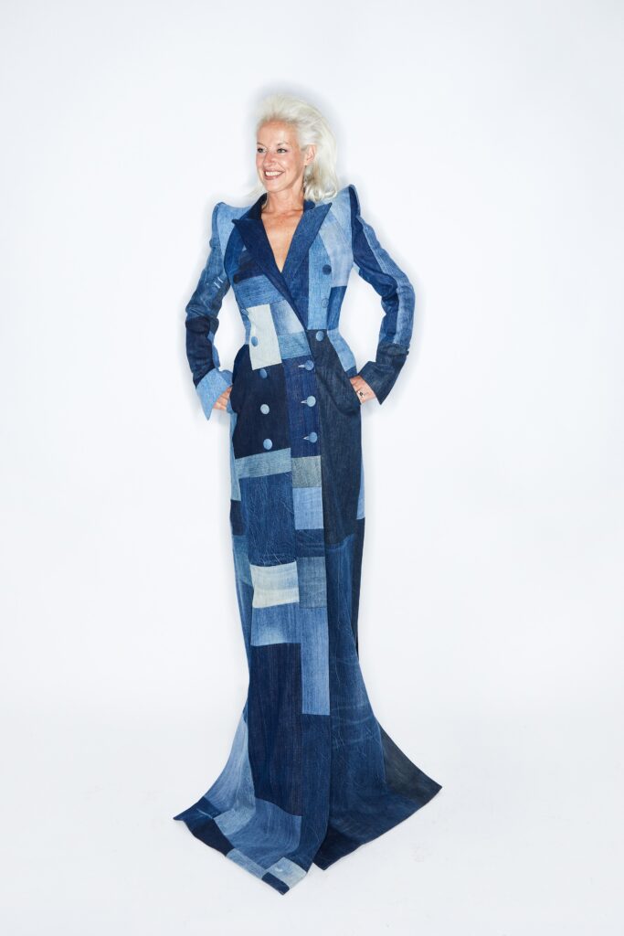 A fitted blue denim dress with long sleeves and an asymmetric design detail.