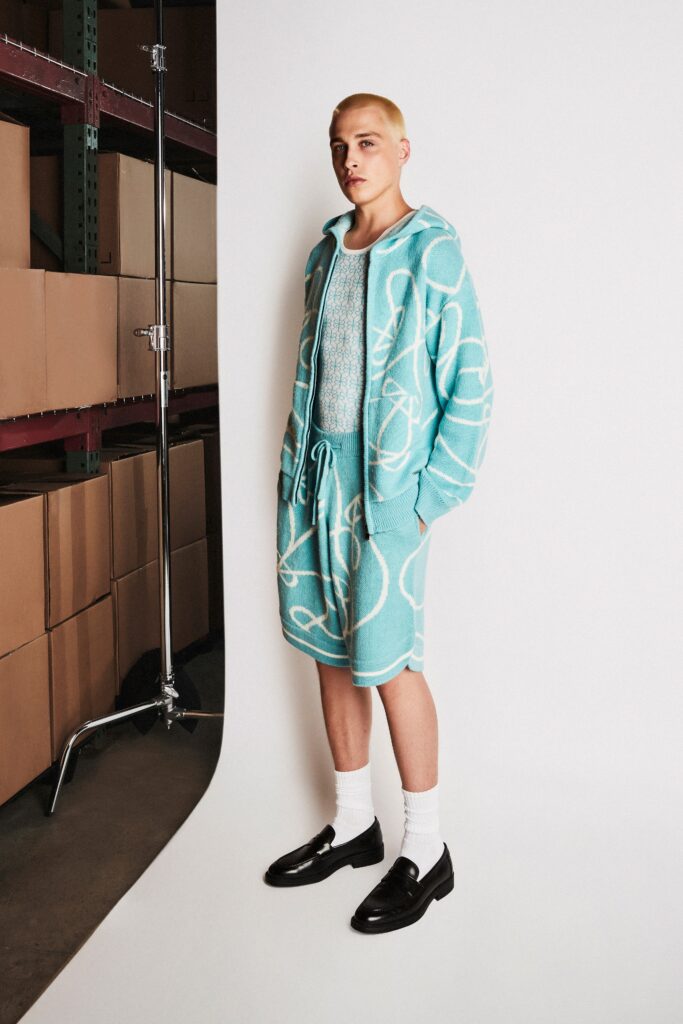 A relaxed blue cotton coat sweater with a hood and long sleeves featuring a printed design.