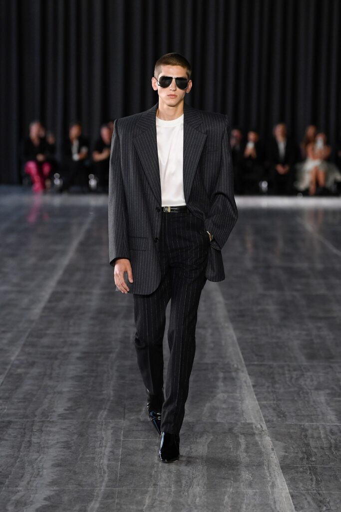 A tailored black striped blazer paired with fitted pants and a white shirt.