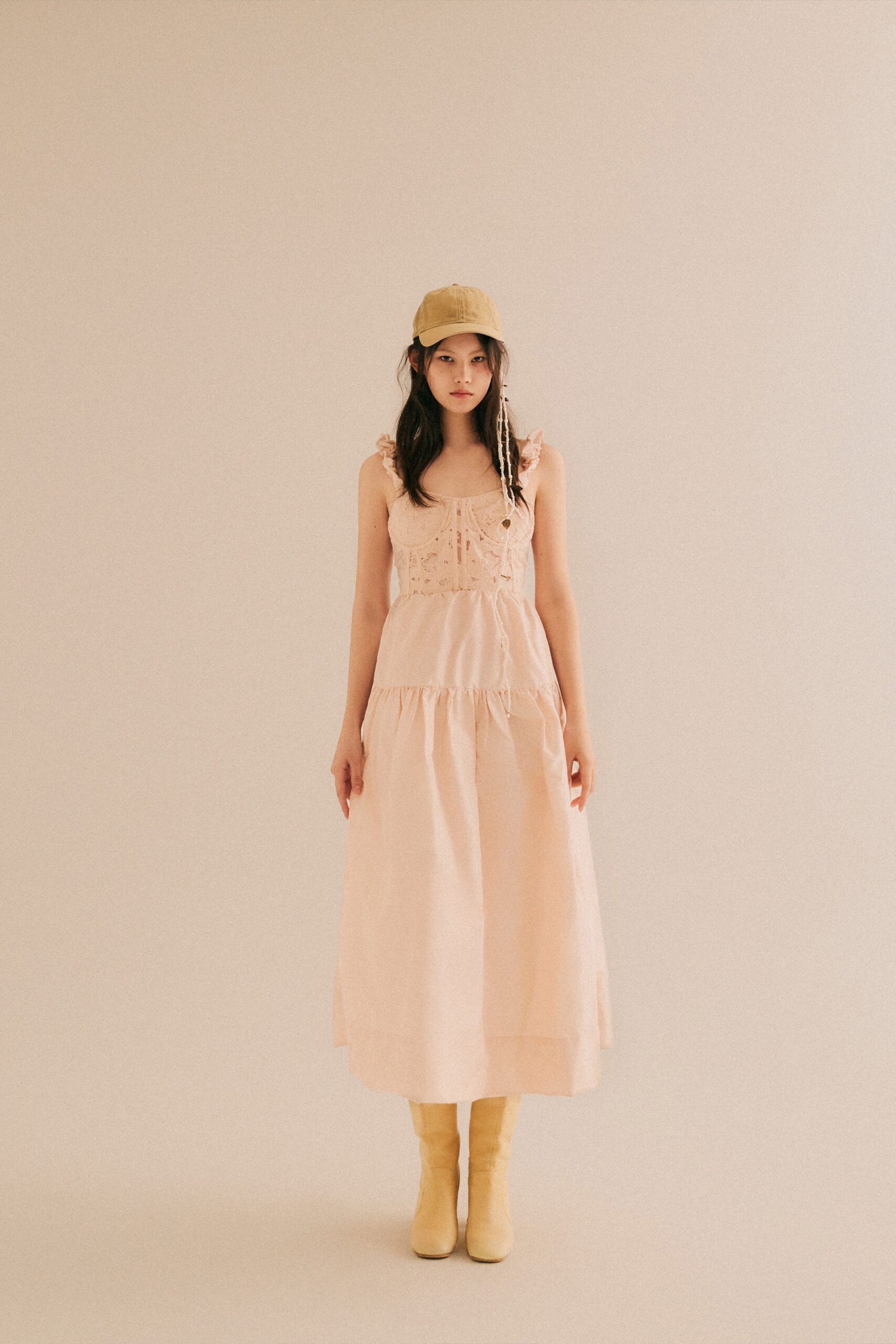 A relaxed pink cotton sleeveless dress with a V-neckline and tiered design.