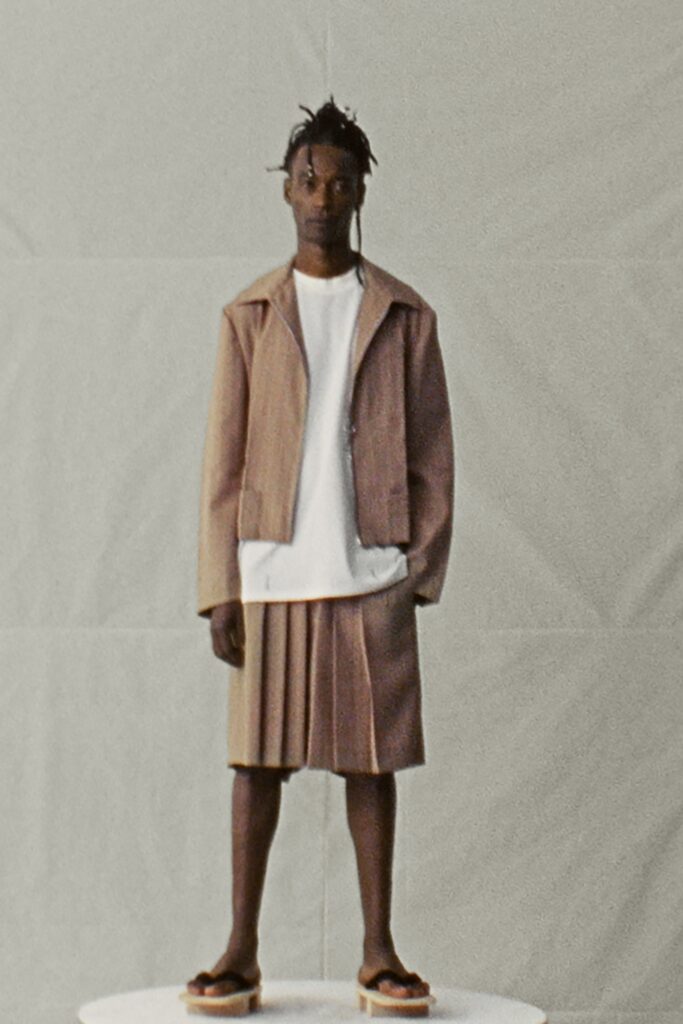 A relaxed brown cotton jacket paired with a pleated skirt for a contemporary look.