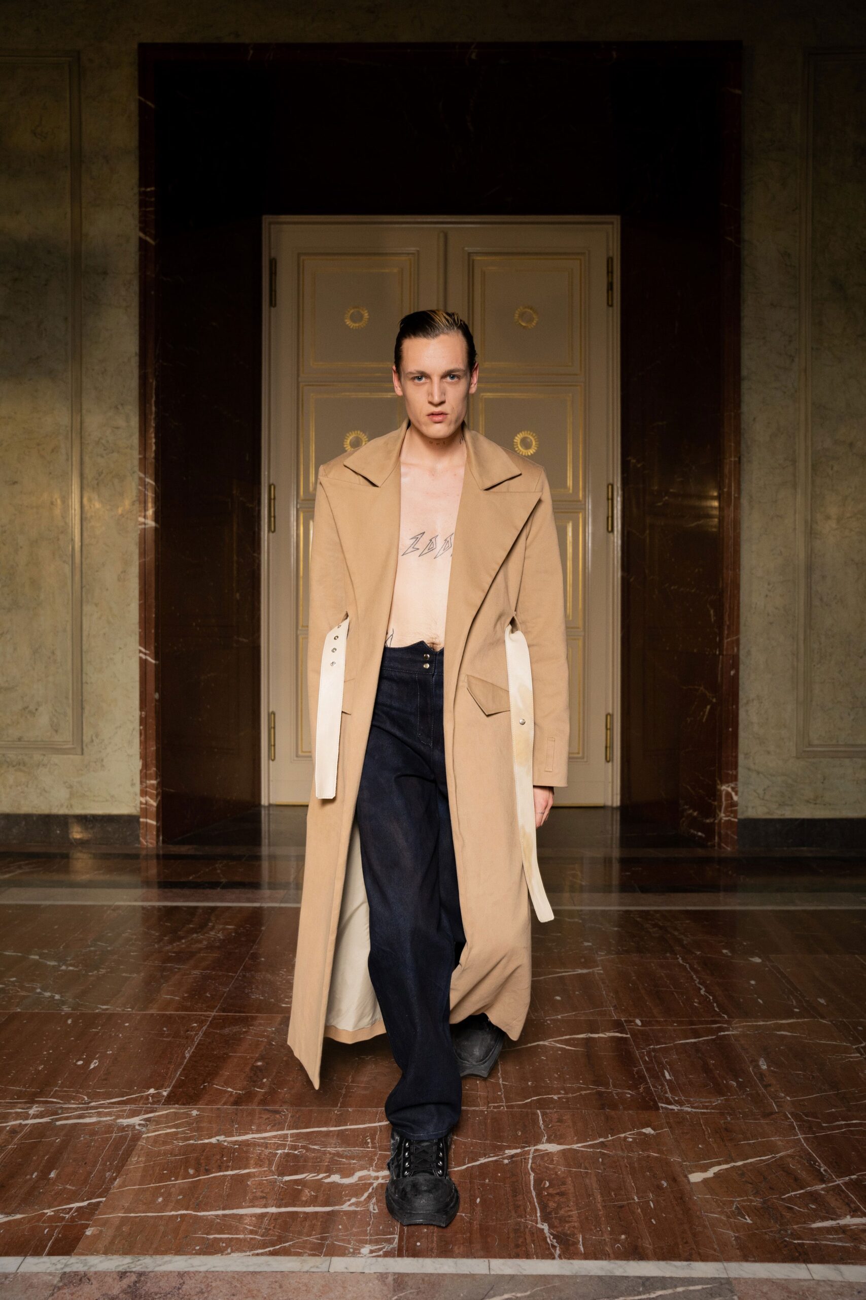 A relaxed beige wool coat paired with straight-leg black denim pants.