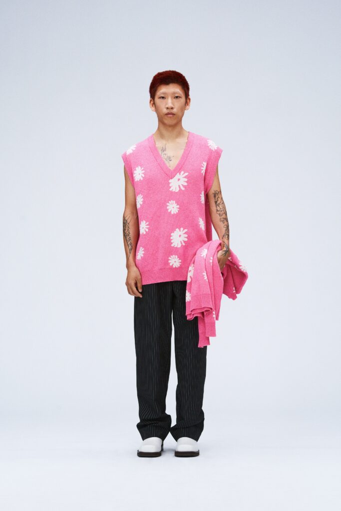 pink sleeveless sweater with black pants
