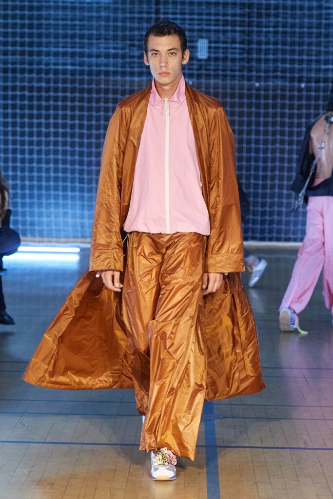 A relaxed brown silk coat paired with pink pants, featuring a long-sleeve collared design.