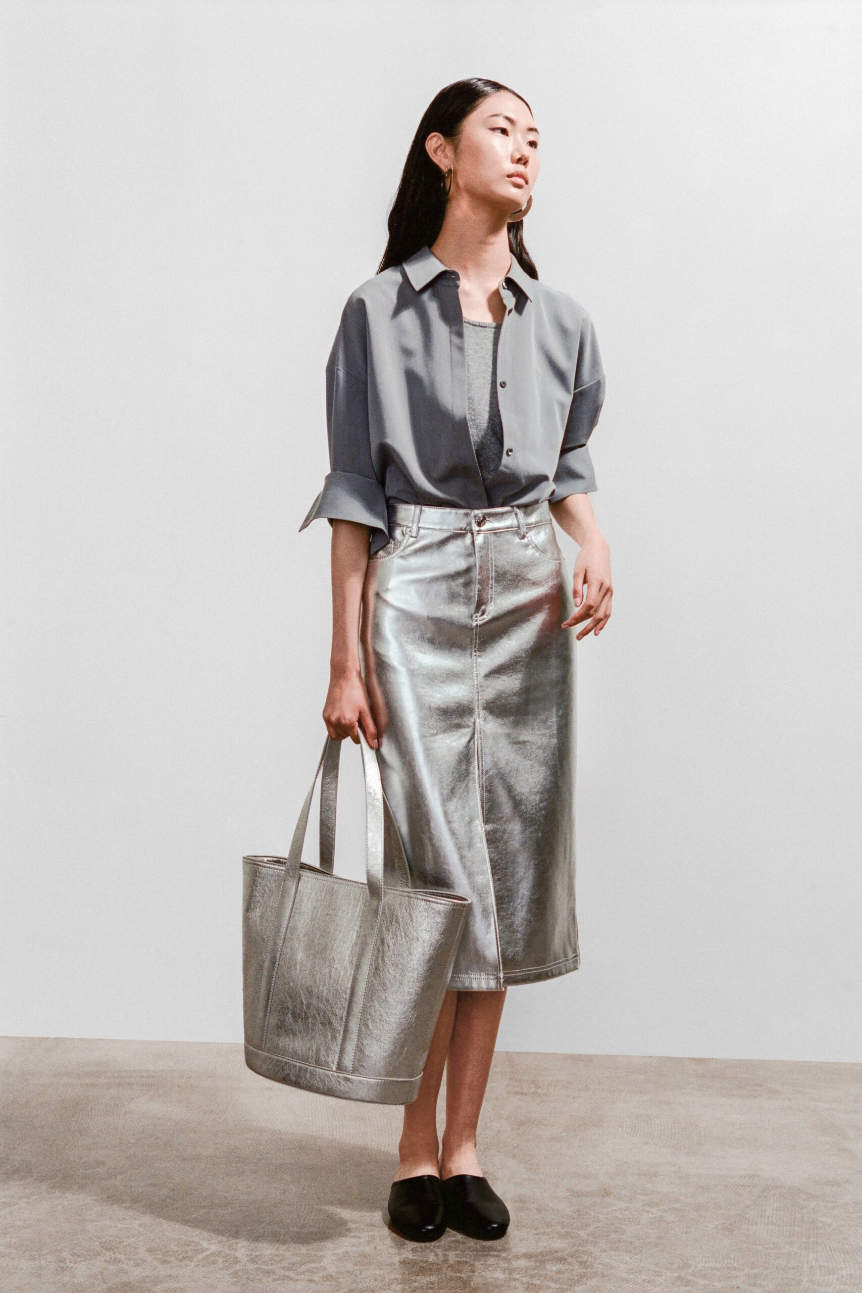 A fitted gray collared shirt paired with a straight-leg silver skirt.