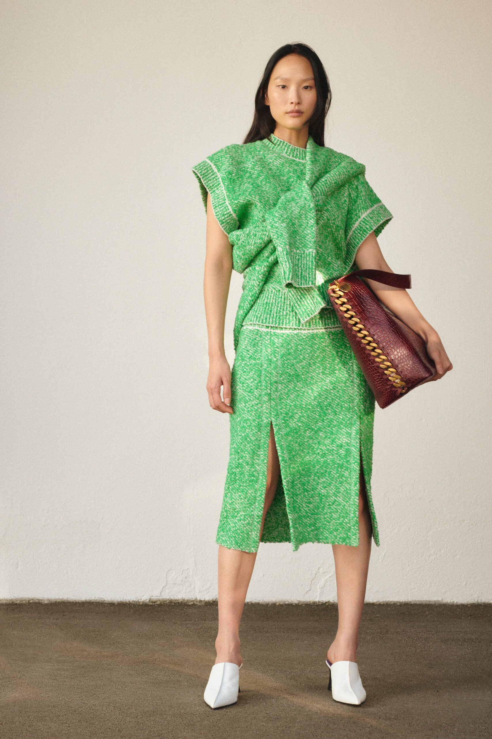 A fitted green cotton dress with a V-neckline and a slit detail.
