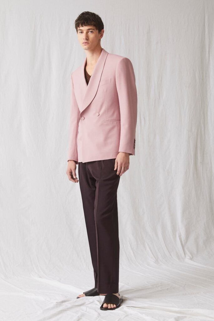A tailored pink double-breasted blazer paired with black pants for a sophisticated look.