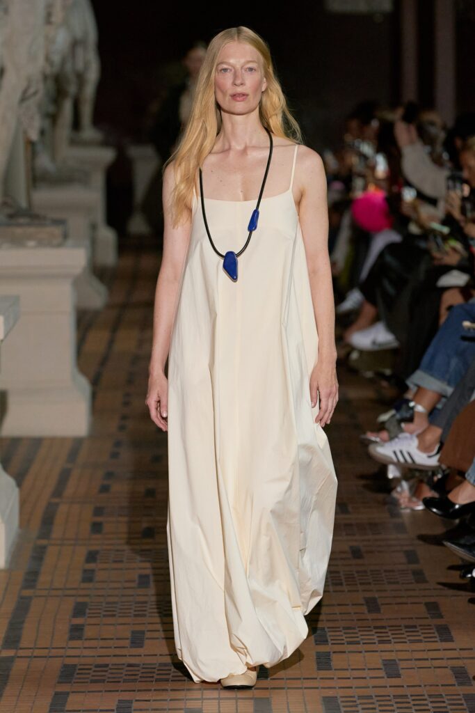A relaxed cream silk sleeveless dress with a high neckline and maxi length.