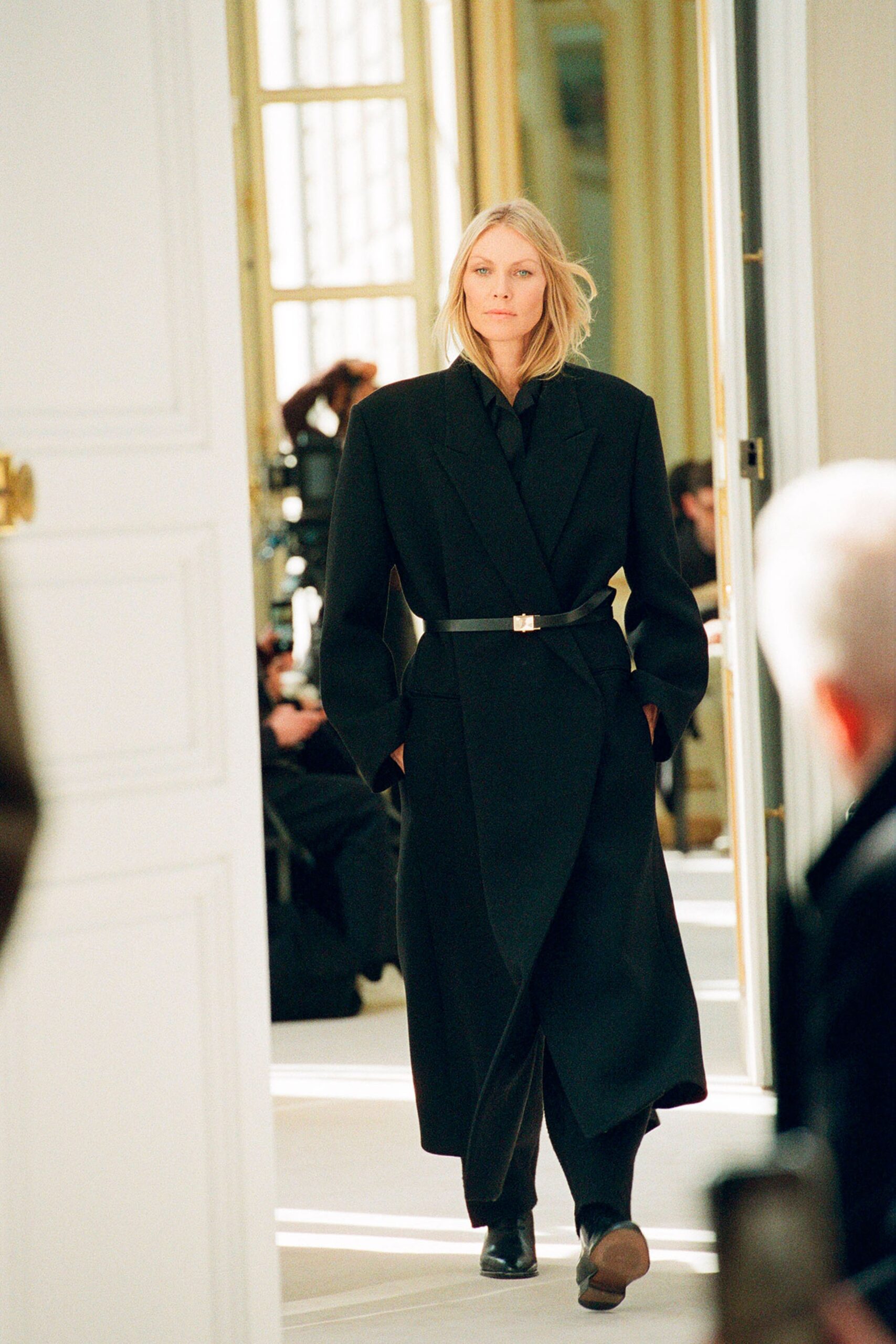 An oversized black wool coat with long sleeves and a belted design.