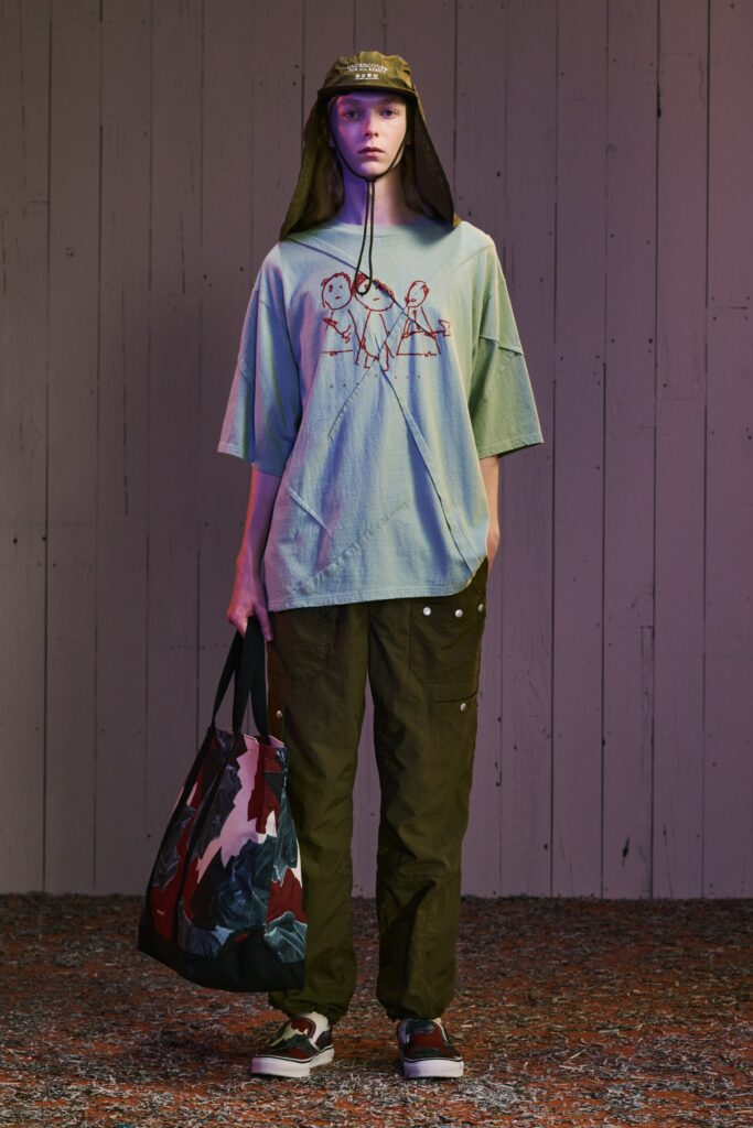A relaxed blue printed t-shirt paired with high-waisted green pants for a casual look.