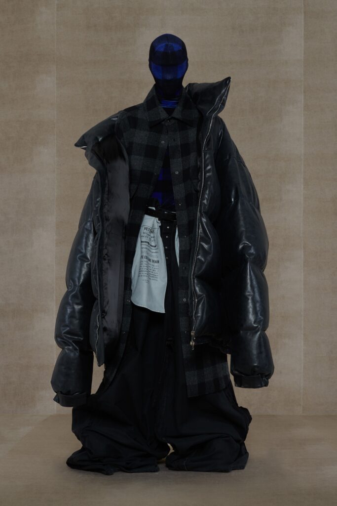 An oversized black leather jacket paired with loose-fitting pants, featuring a layered design.