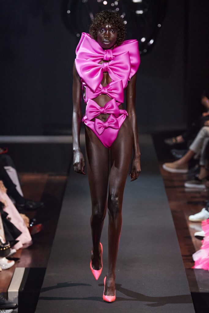 A fitted pink silk bikini with cutout details and fringed accents.