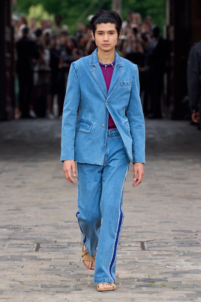 A relaxed blue denim jacket with long sleeves paired with straight-leg denim pants.