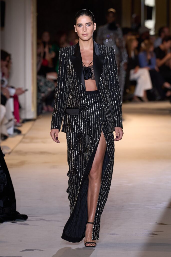 A fitted black silk sleeveless dress with a V-neckline and a high slit.